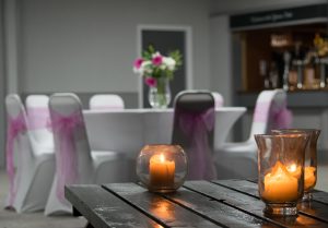Function Room 3 room decorated with white tables, pink chair sashes and flower displays for an evening wedding reception